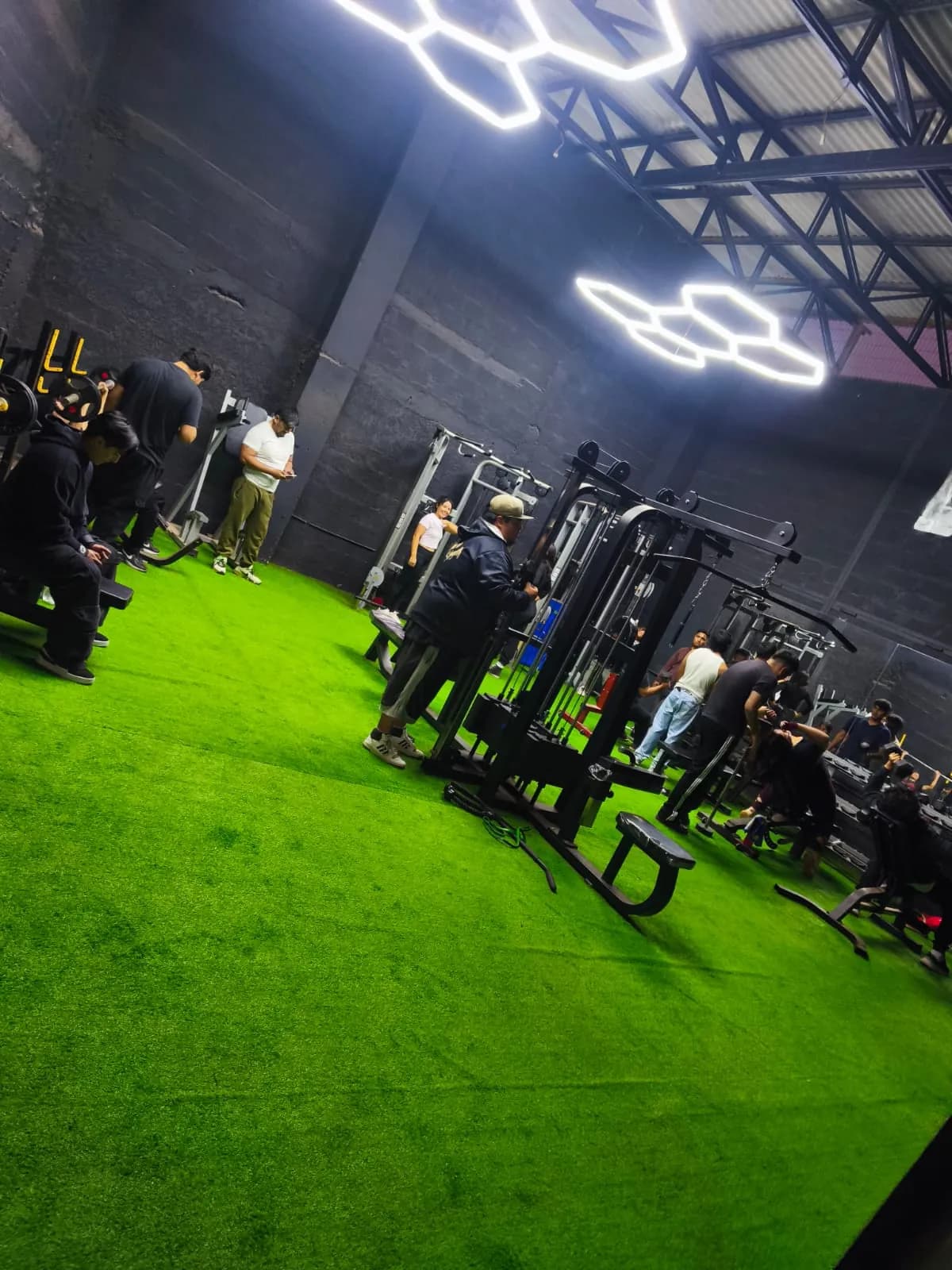 Socios entrenando en la sala de ONEX bajo las luces hexagonales