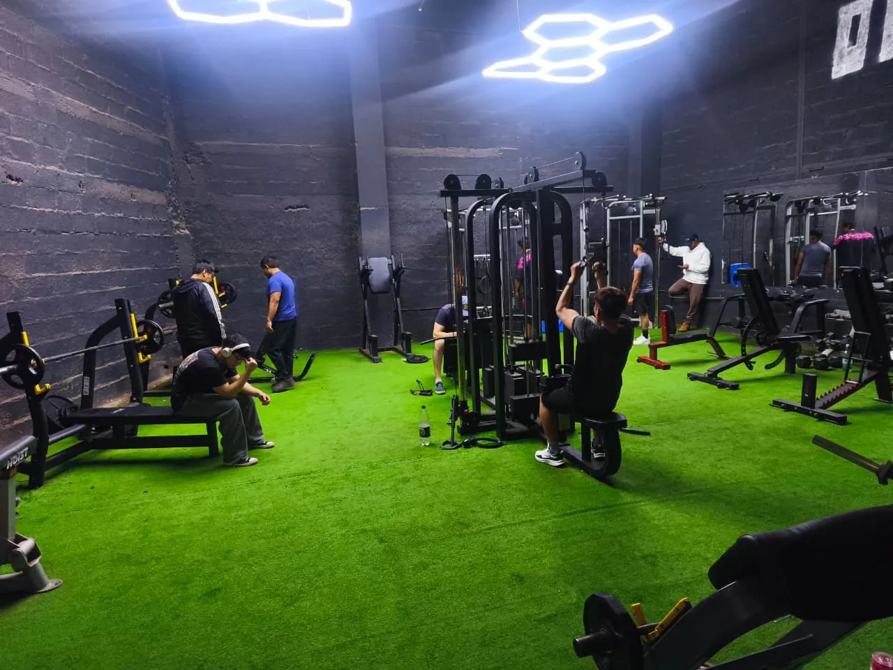 Socios entrenando en la sala de ONEX Club bajo las luces hexagonales